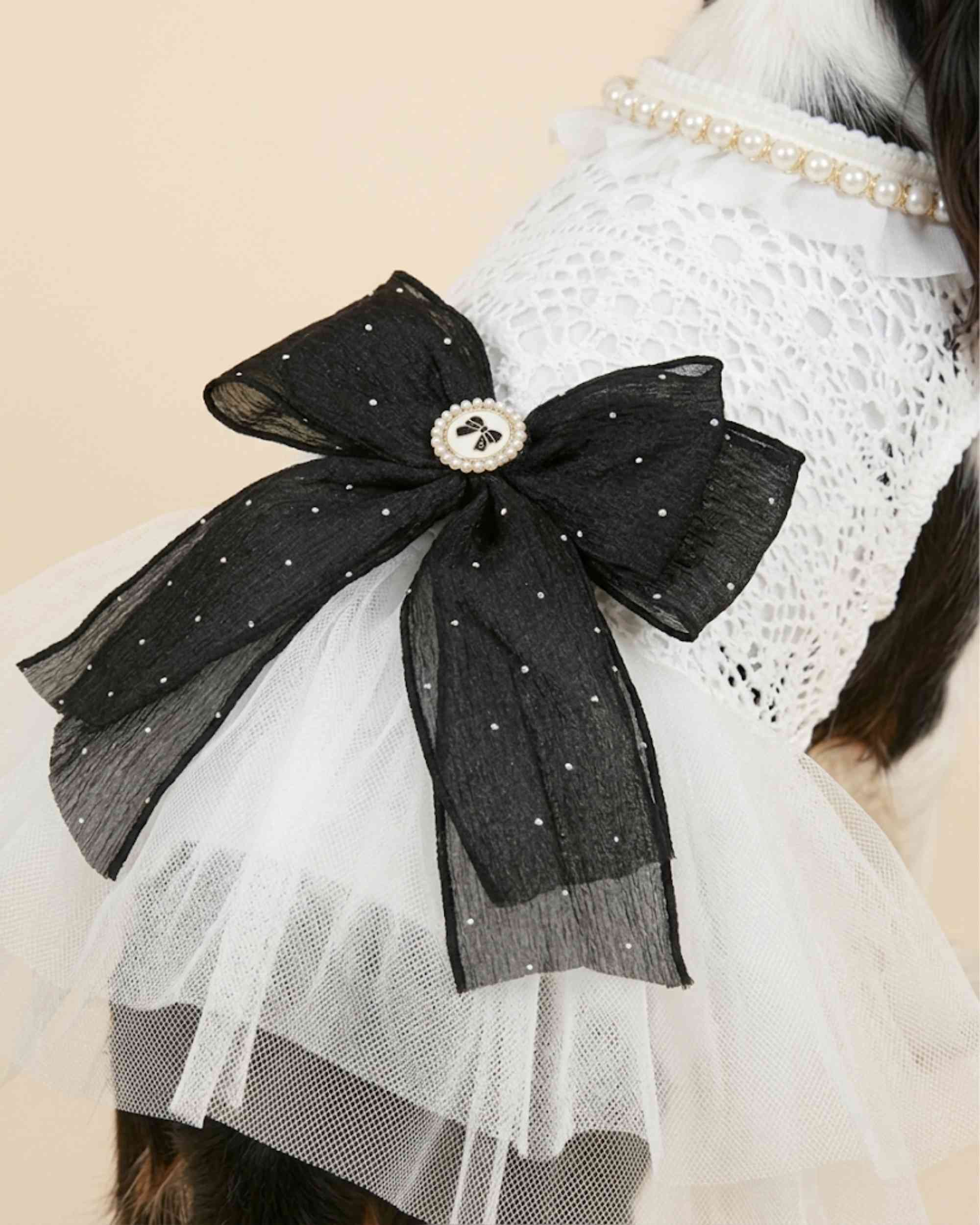 Close-up of the black dotted bow, pearl centre ornament, white lace bodice and layered tulle on the pet dress