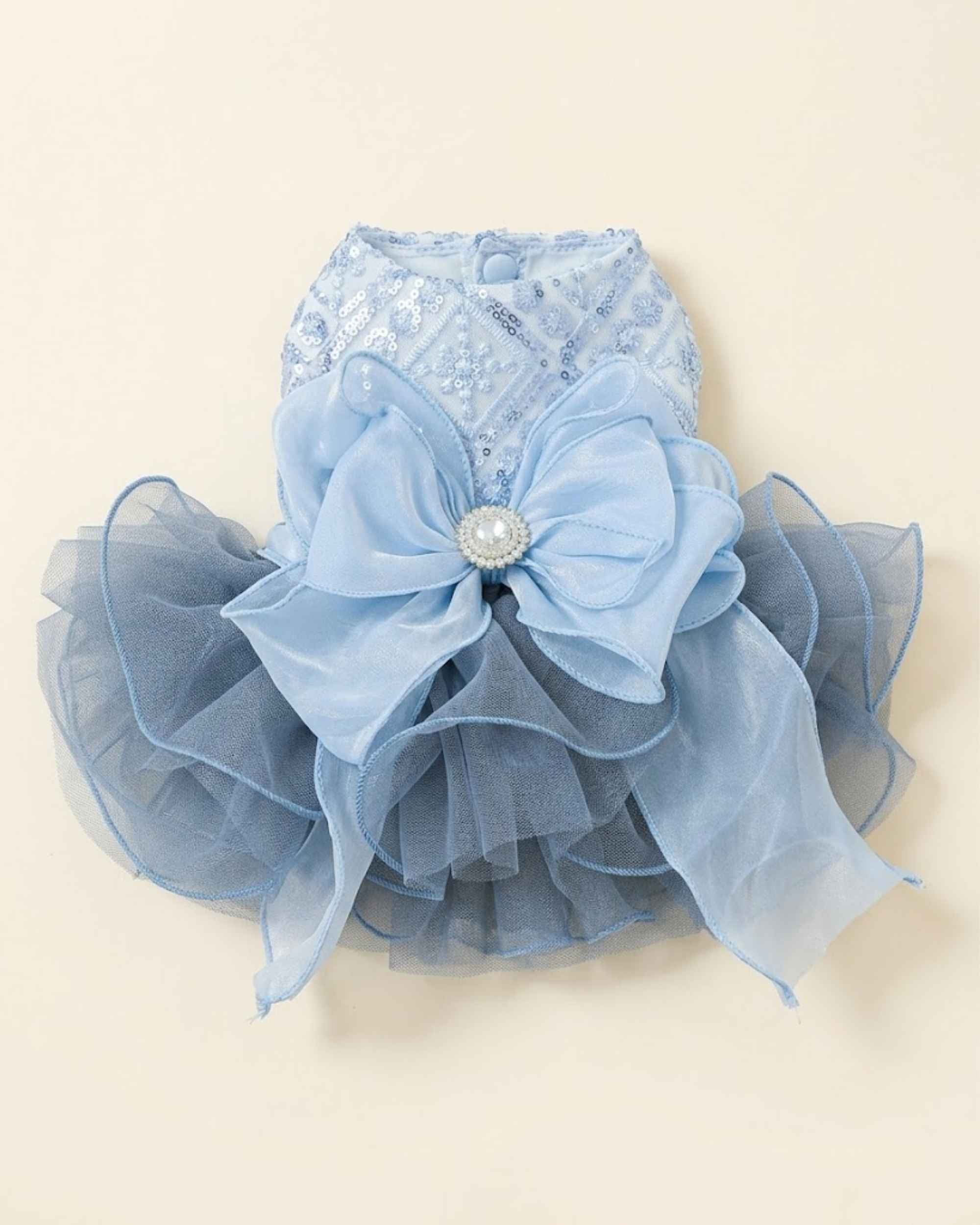 Back flat lay of a celestial blue sequin pet dress with an oversized layered blue bow, crystal centre brooch and voluminous tulle skirt.