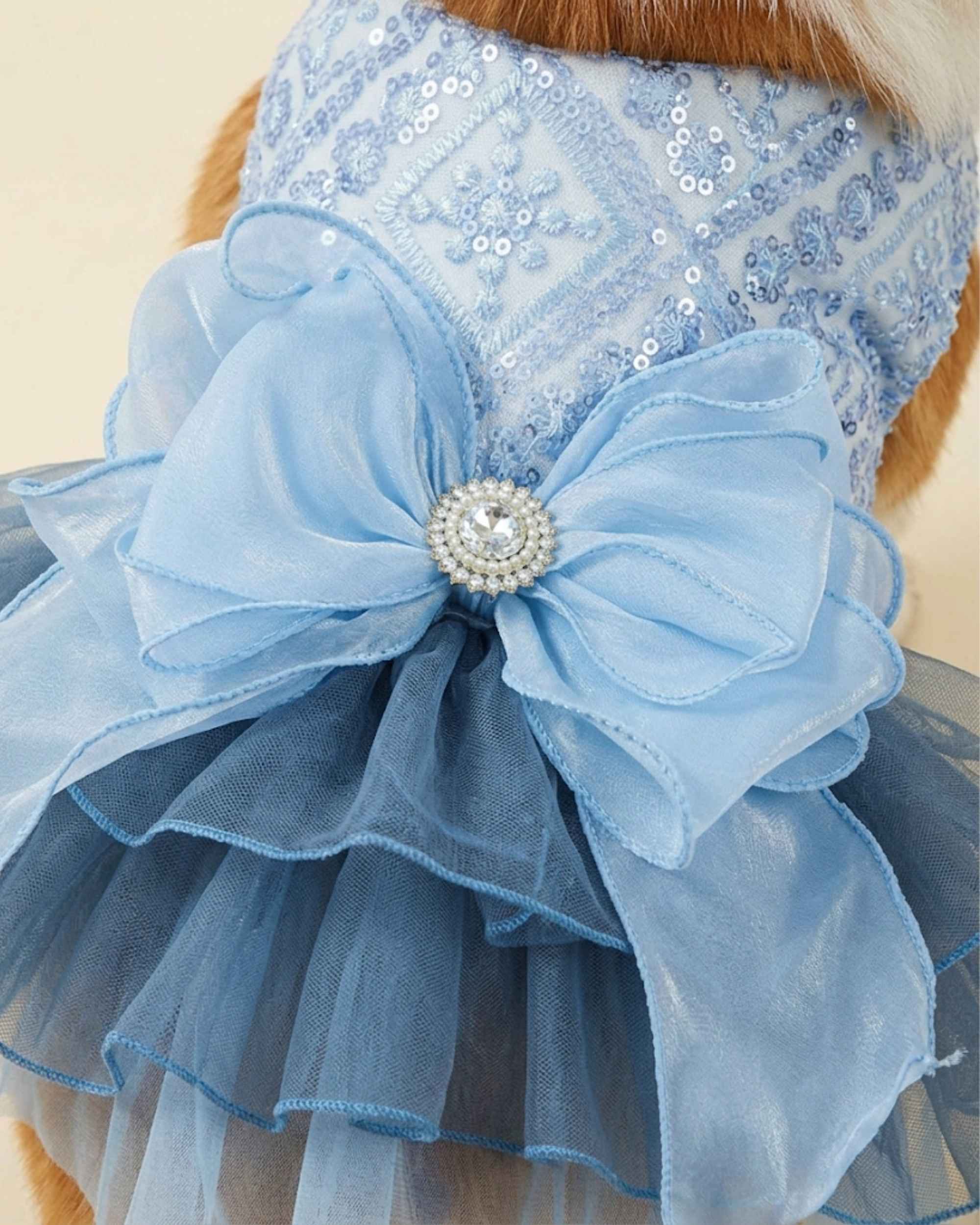 Close-up of the pale blue sequin embroidered bodice, oversized layered organza bow, crystal brooch and smoky blue tulle skirt.
