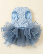 Front closure flat lay of a celestial blue pet dress with two leg openings, three pale blue snap buttons and a layered smoky blue tulle skirt.