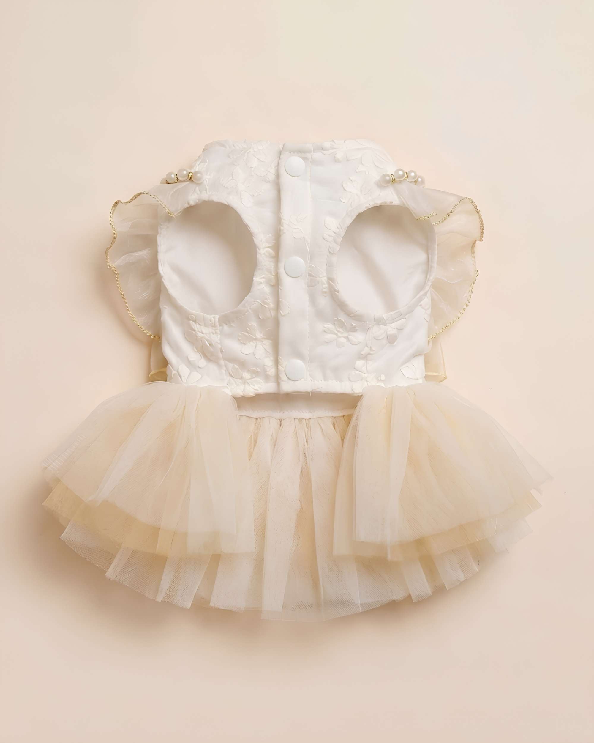 Flat lay photograph of the chest and underside construction showing the three white snap buttons and wide leg openings.