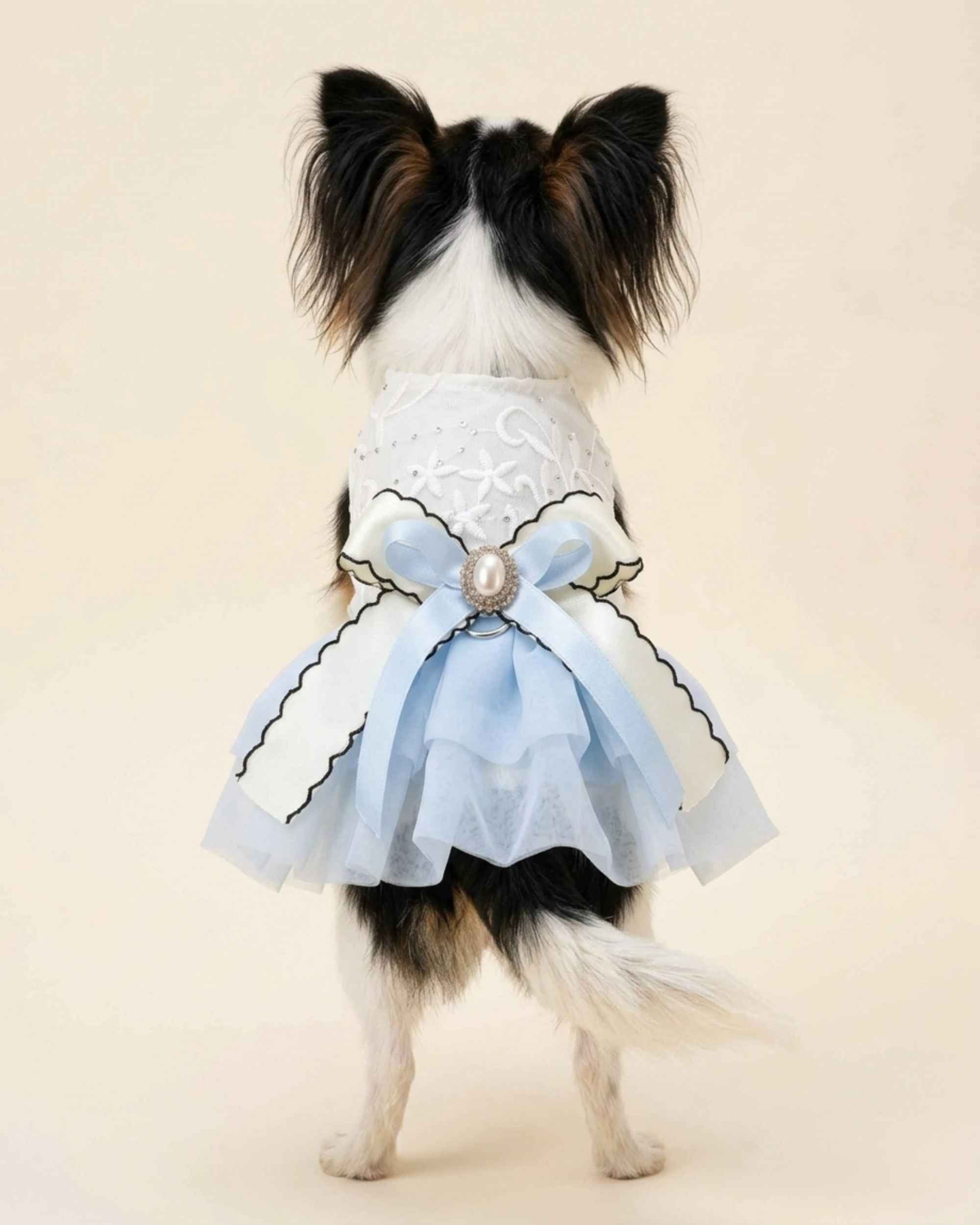 Full back view of the Cinderella Blue pet dress showing its pearl brooch, pale blue satin bow, ivory ribbon and layered tulle skirt