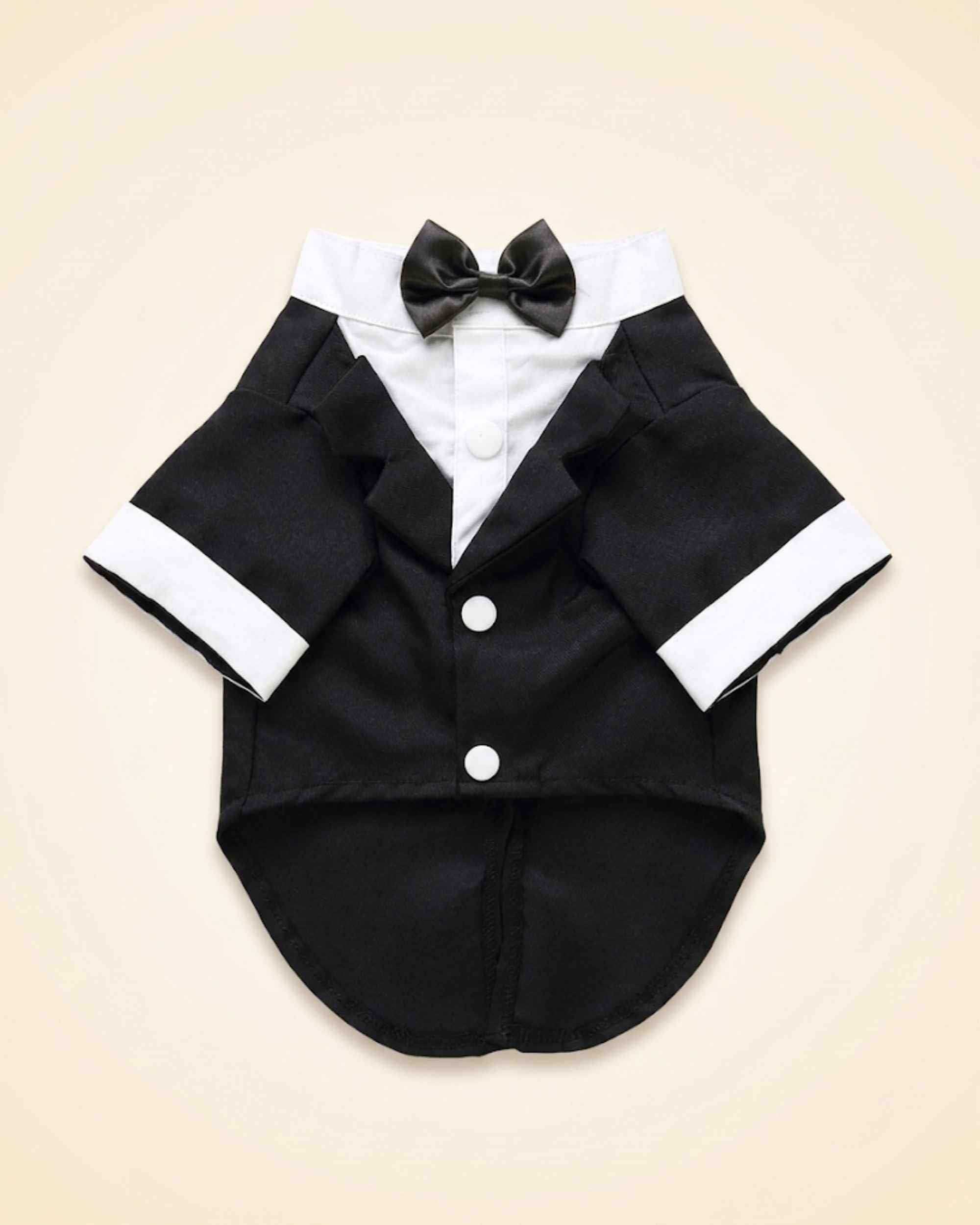 Front flat lay of the midnight-black pet tuxedo with satin bow tie, white shirt panel, lapels, cuffs and buttons