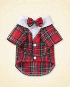Red tartan pet tuxedo with a matching plaid bow tie, white fold-over collar, short sleeves and white front buttons shown in a flat lay.
