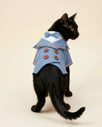Rear view of a black cat wearing the Denim Blue Double-Breasted Pet Tuxedo with matching bow tie, striped lapels and four brown buttons.