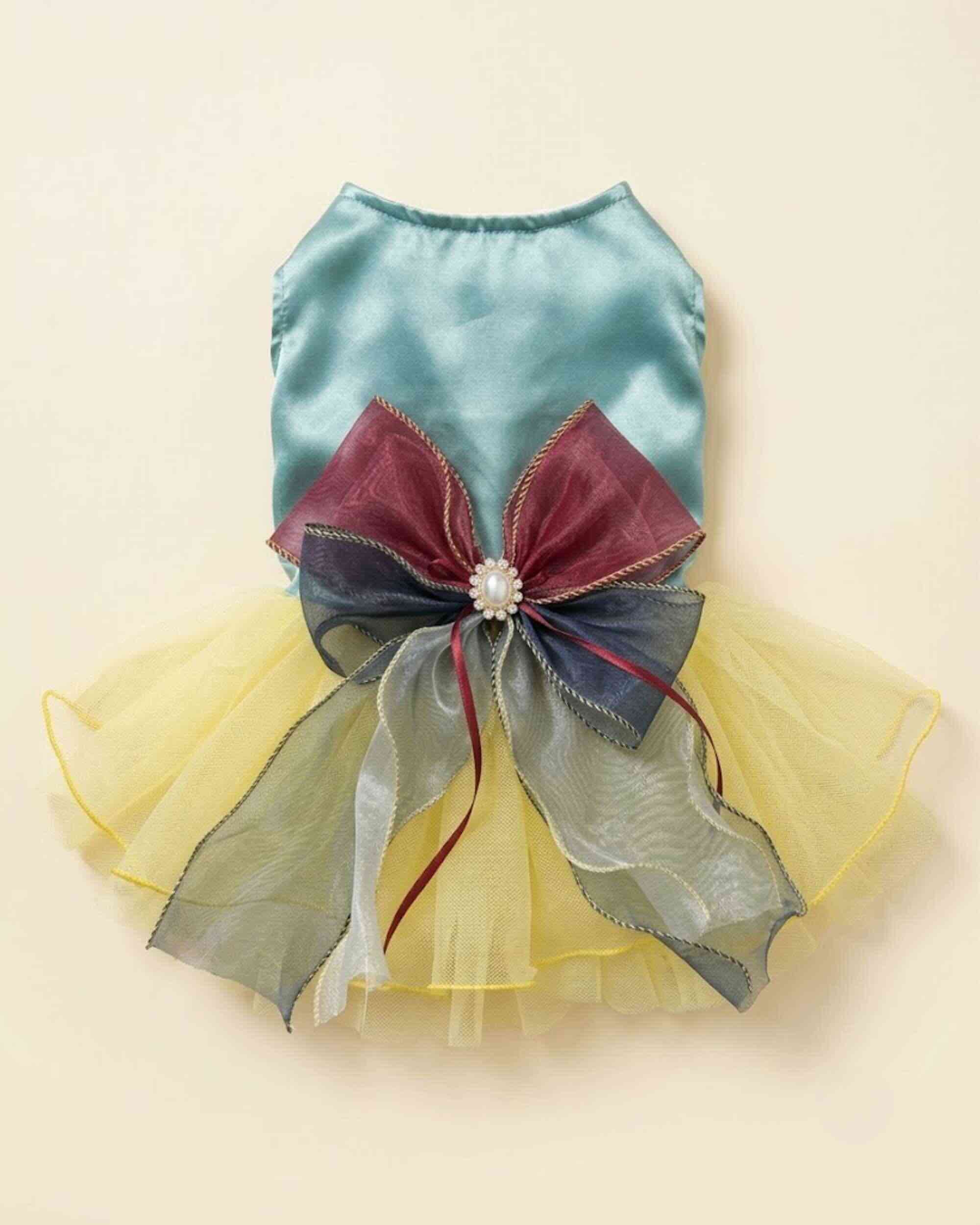 Flat lay of an aqua satin pet dress with yellow tulle skirt and oversized burgundy navy and silver layered bow
