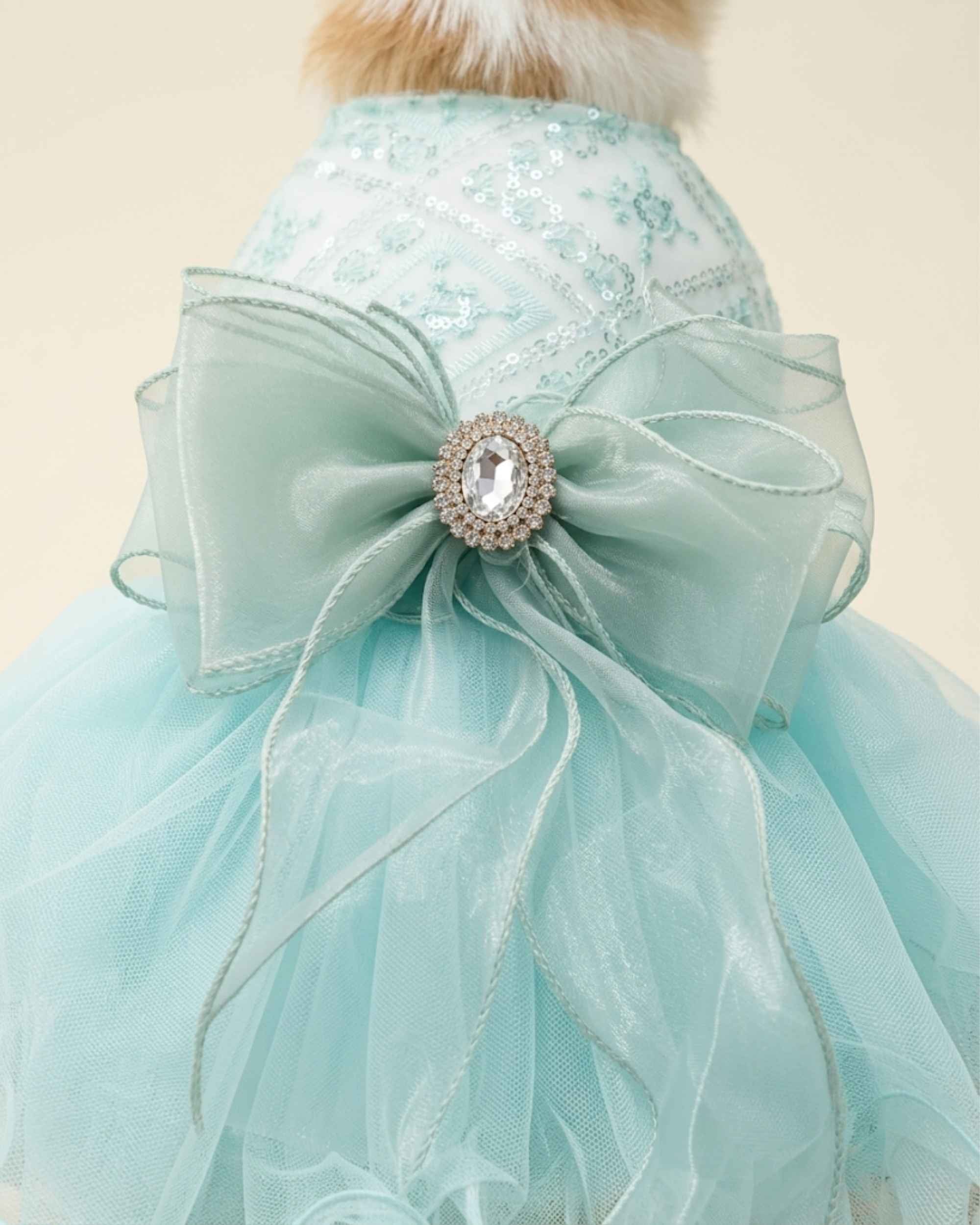 Close-up of the seafoam mint organza bow, crystal-style centrepiece and embroidered sequin bodice.