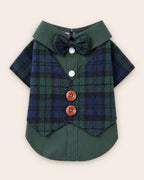 Display-side flat lay of the green and navy plaid pet waistcoat shirt with a matching bow tie, two white snaps, two brown buttons and layered green hem.