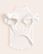 Chest-side flat lay showing the ivory pet turtleneck’s leg openings, satin ruffles and softly gathered belly panel.