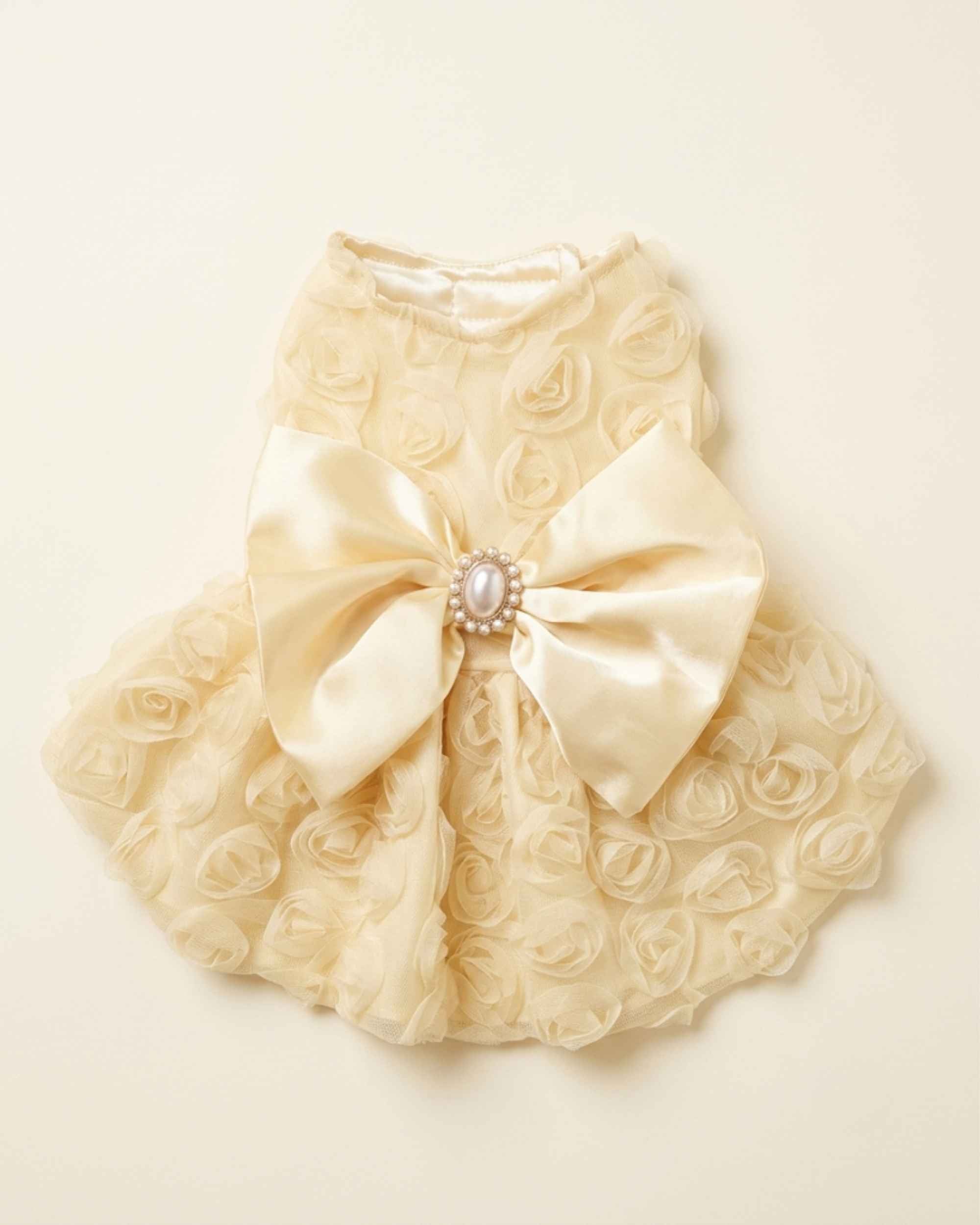 Flat lay product photograph showing the full back of the luxury rose lace pet dress with its pearl bowknot and tiered skirt.