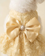 Close-up macro view of the luxury pet dress showing the pearl brooch, satin bowknot, and 3D rose lace mesh texture.