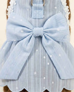 Close-up of the sky blue pet harness dress showing the oversized striped bow, silver D-ring and reinforced stitching