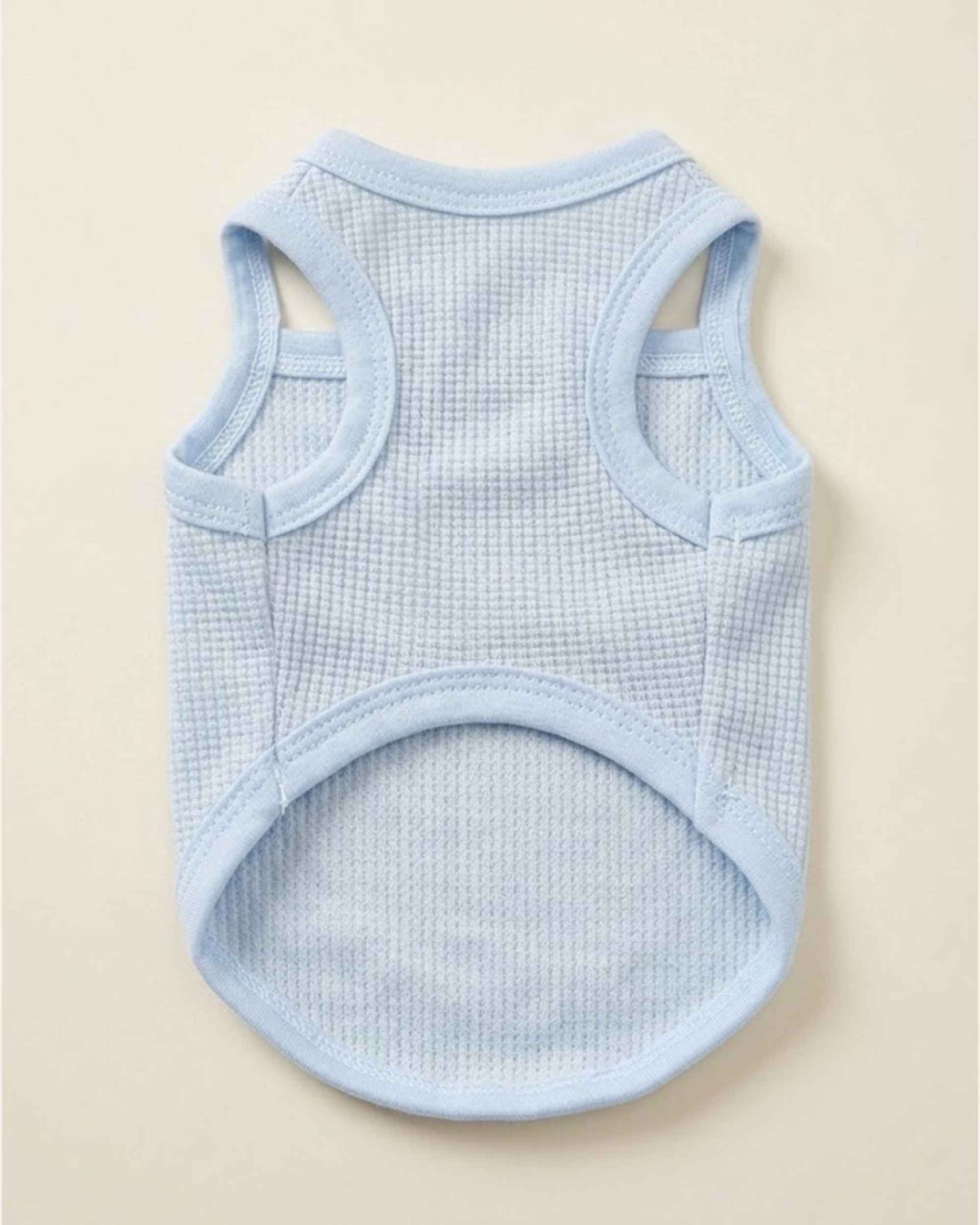 Flat lay showing the breathable ribbed cotton underside and leg openings of the powder blue pet vest dress.
