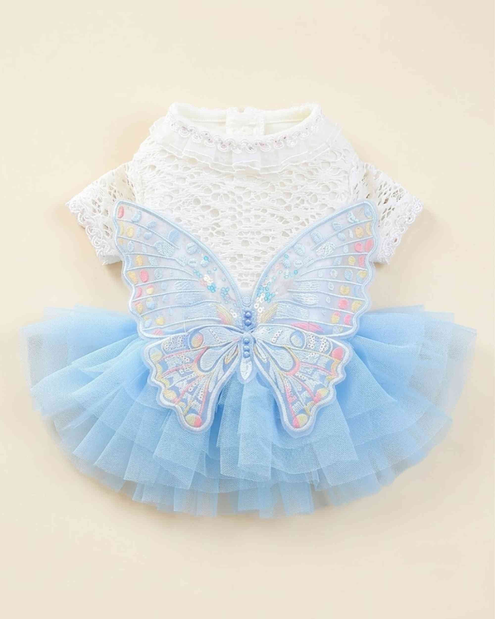 Back flat lay of a white lace pet dress with embroidered butterfly wings and a blue tulle skirt.