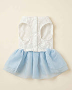 Closure-side flat lay of a sky blue pet dress with a white embroidered bodice, leg openings and snap fastenings.