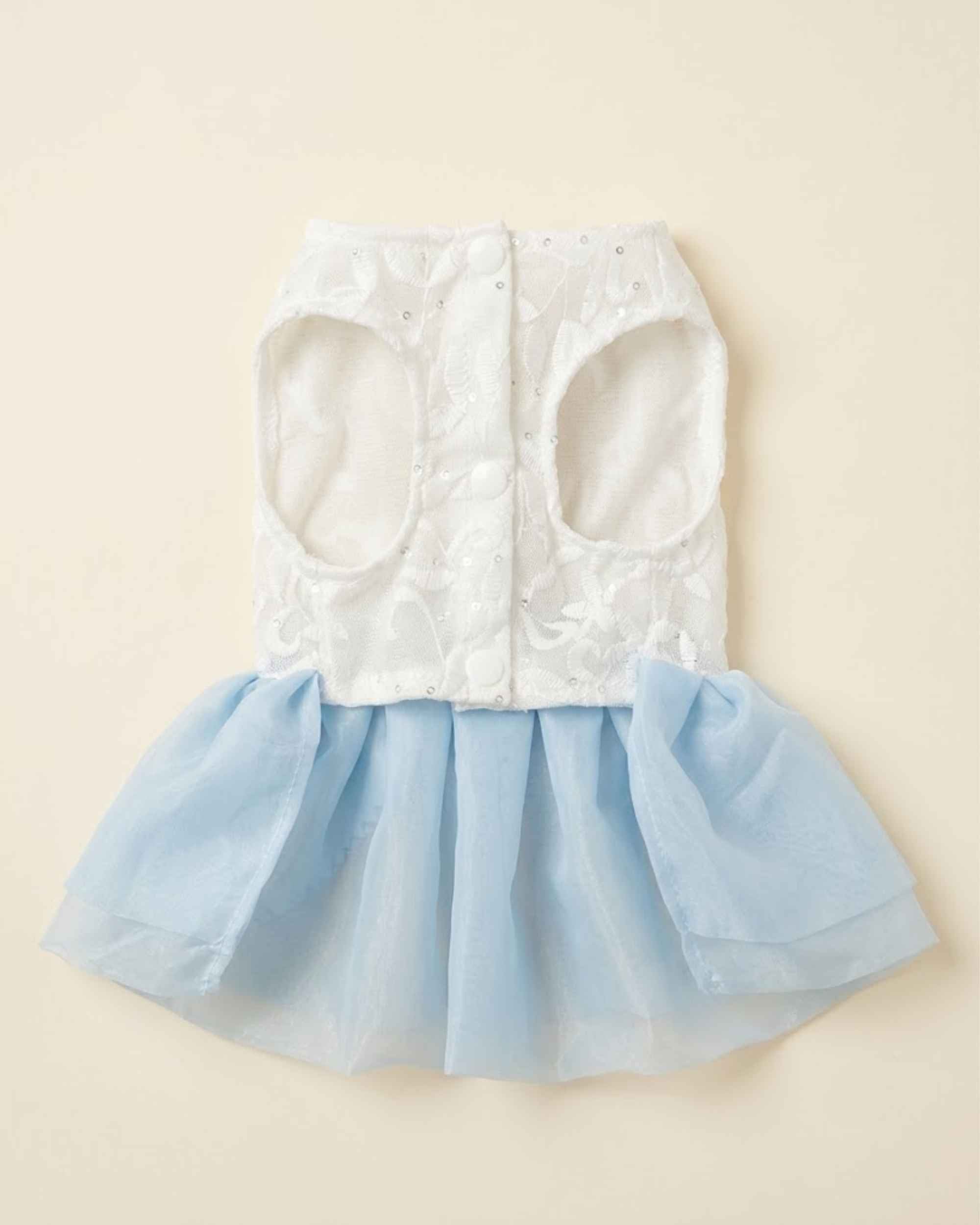 Closure-side flat lay of a sky blue pet dress with a white embroidered bodice, leg openings and snap fastenings.