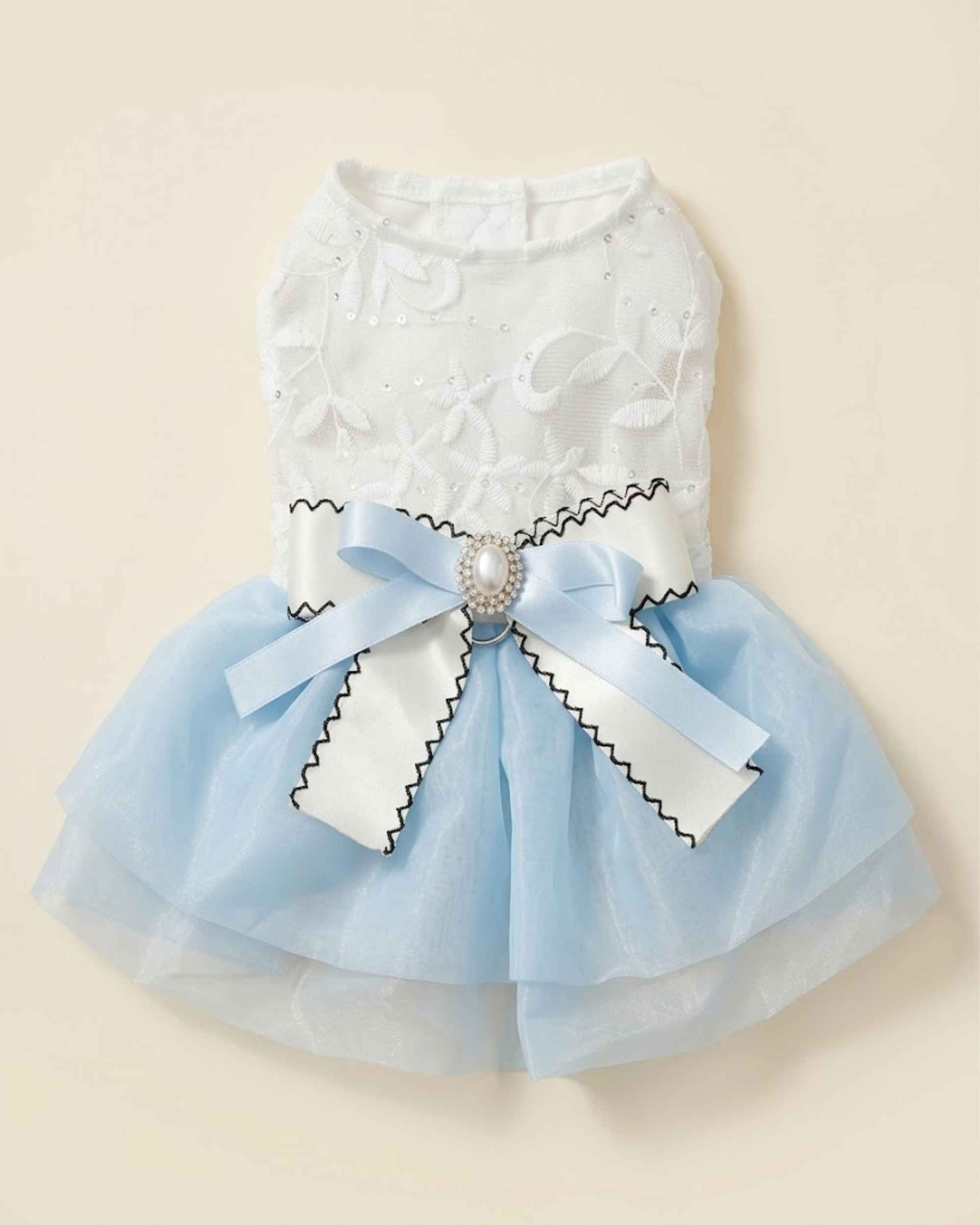 Back flat lay of a sky blue pet dress with a white embroidered bodice, layered ribbon bow and pearl-style brooch.