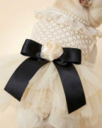 Close-up of the black satin bow, ivory fabric rose, pearl collar trim and layered ivory tulle on the pet dress.
